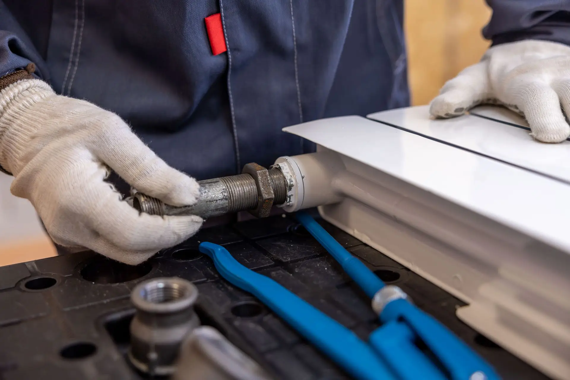 Plumber repairing a radiator valve in a home