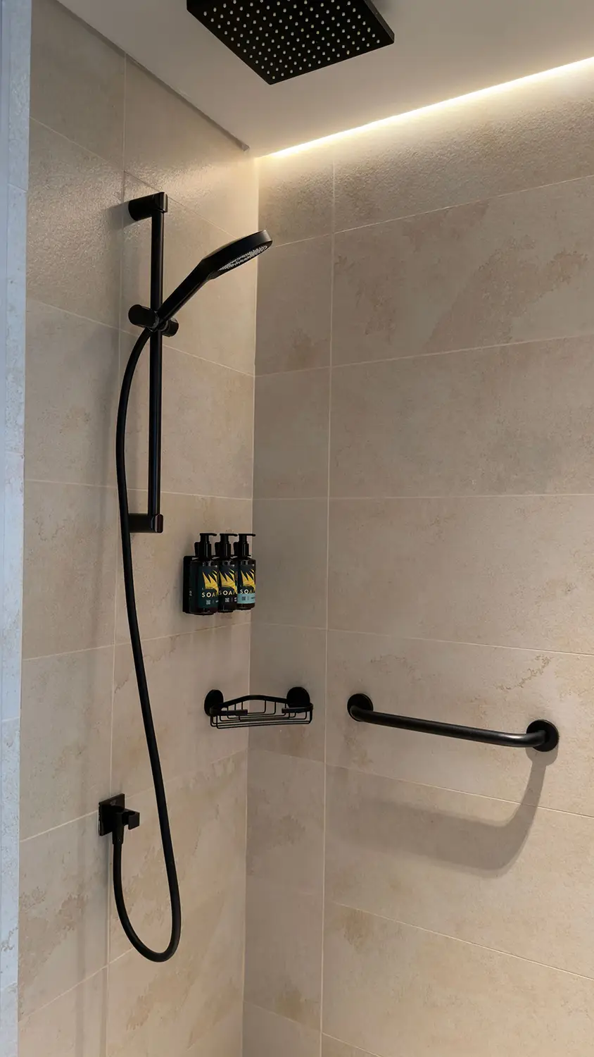 Contemporary black finish rainfall shower fitting in a newly renovated bathroom